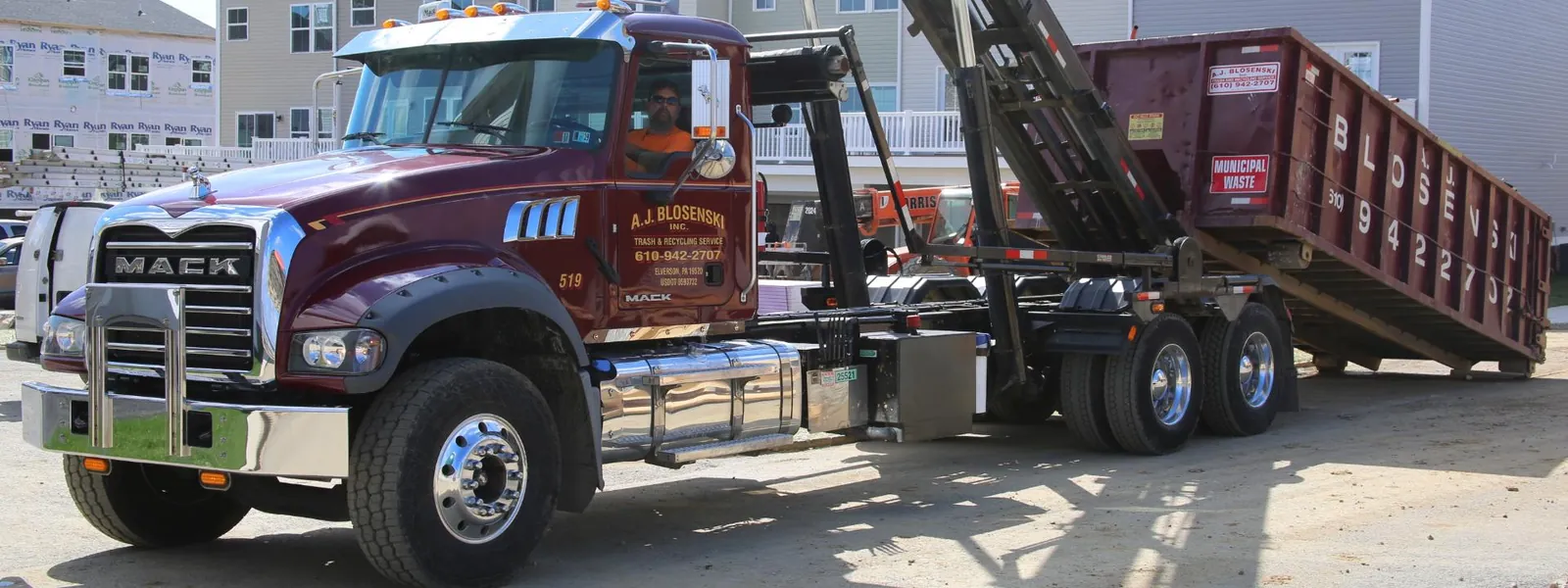 Dumpster Dispatch Software: How to Dispatch in Seconds — A.J. Blosenski Mack roll-off truck delivering a container at a residential construction site
