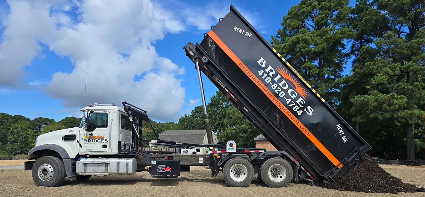 U.S. Landfill Pricing & Database Guide — Bridges Land Management roll-off truck dumping mulch onto a graded site