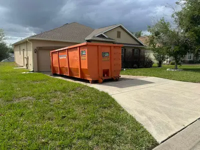 Orange 30-yard Dumpster Strong container delivered in a suburban Florida driveway. Photo courtesy of Dumpster Strong.