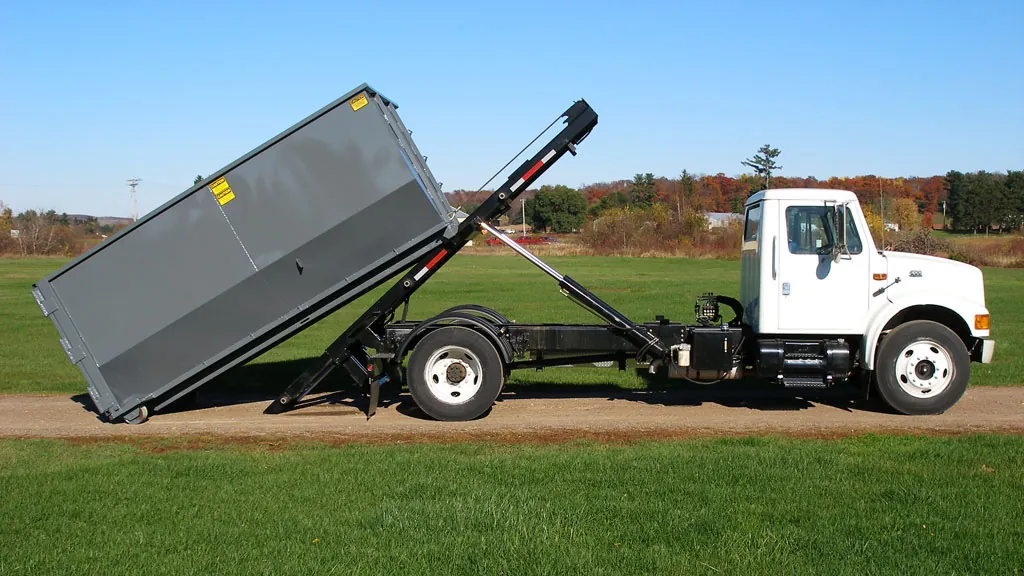 EZ Roll Off truck demonstrating a hoist mechanism with a gray container. Photo courtesy of EZ Roll Off.