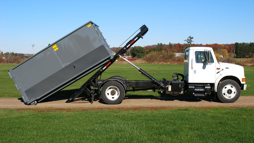 EZ Roll Off truck demonstrating a hoist mechanism with a gray container. Photo courtesy of EZ Roll Off.