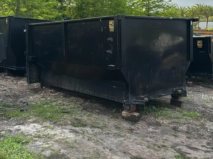 Black roll-off containers lined up in the GM Dumpster yard in Orlando, Florida