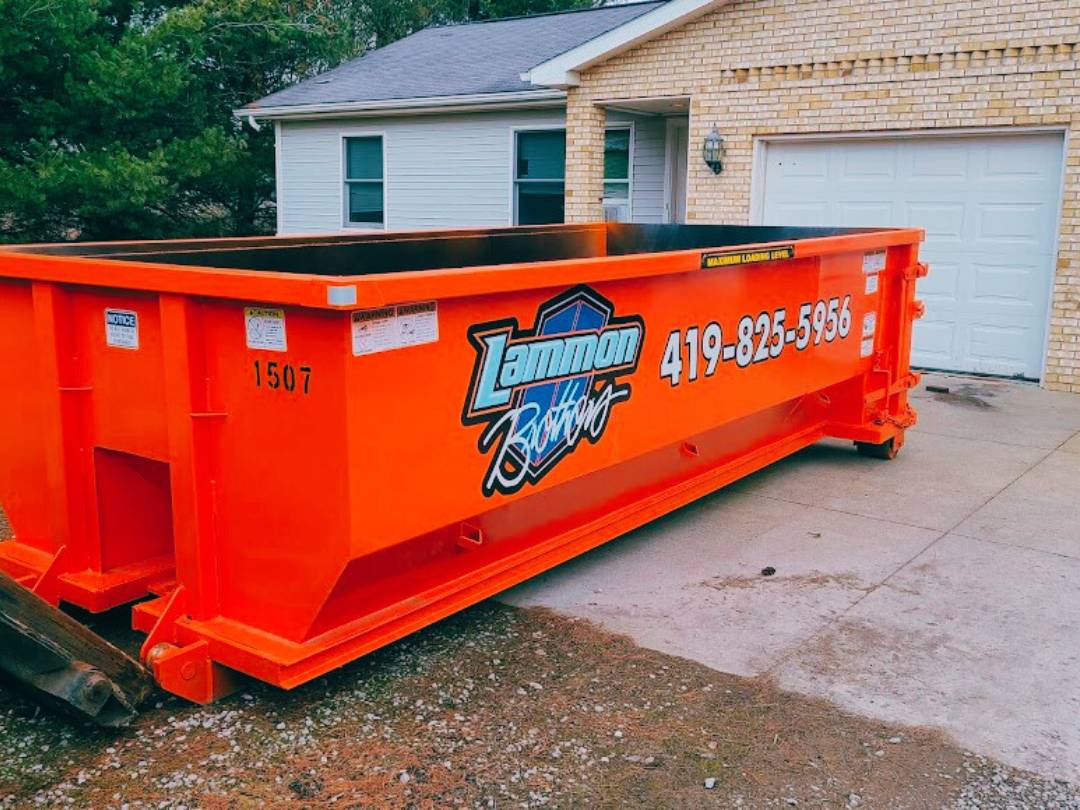 Bright orange Lammon Brothers roll-off dumpster delivered to a residential driveway. Photo courtesy of Lammon Brothers.