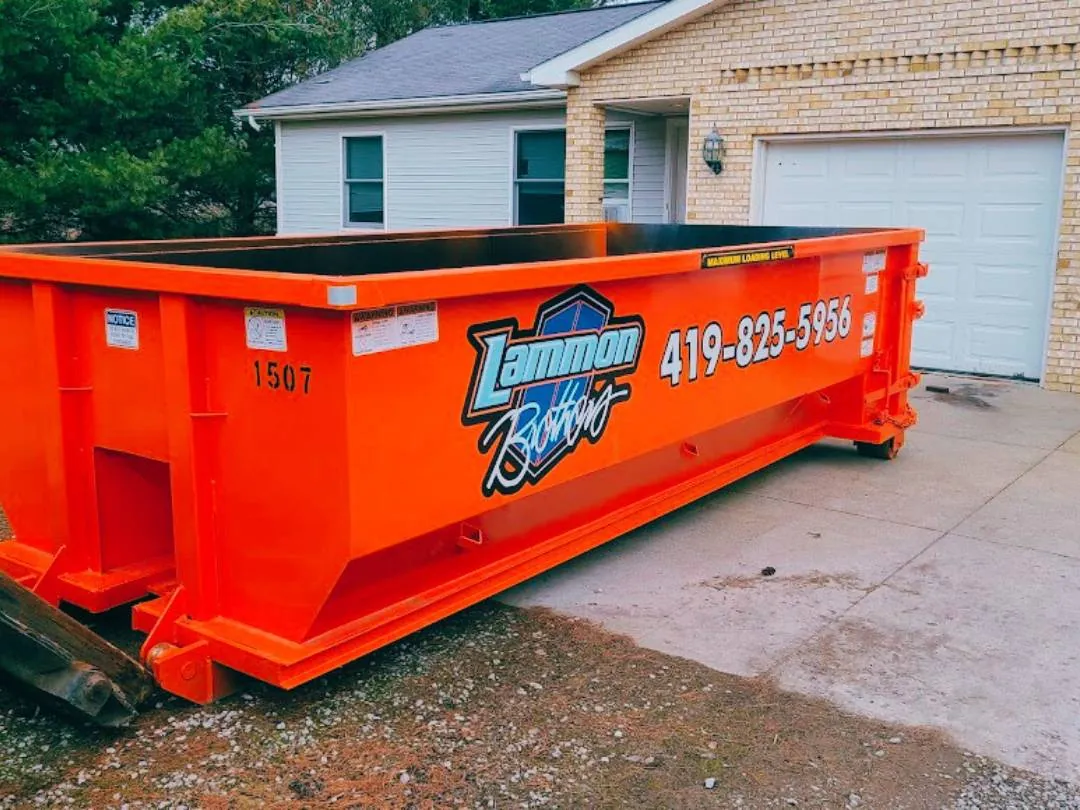 Bright orange Lammon Brothers roll-off dumpster delivered to a residential driveway. Photo courtesy of Lammon Brothers.